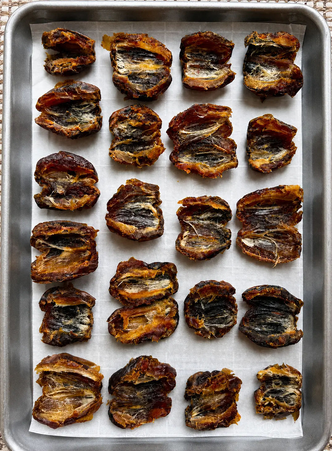 Halved medjool dates on a sheet pan